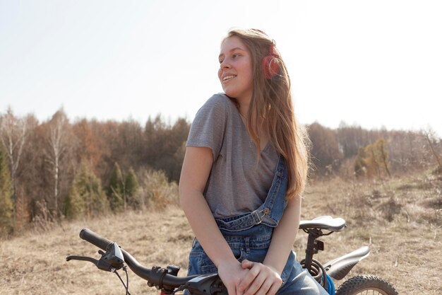 Front view of of carefree woman on bicycle in nature