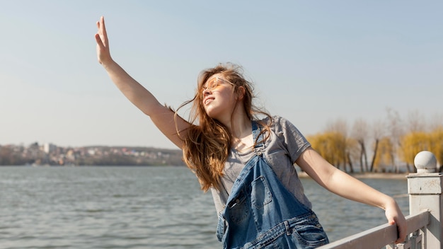 Free Photo front view of of carefree woman posing by the lake