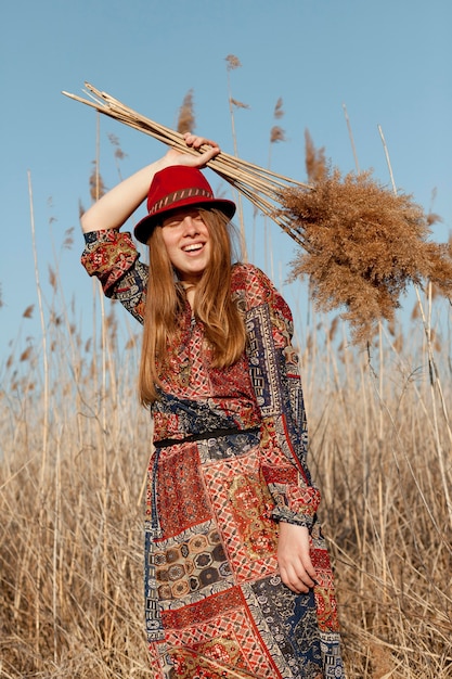 Free photo front view of carefree woman posing in nature field