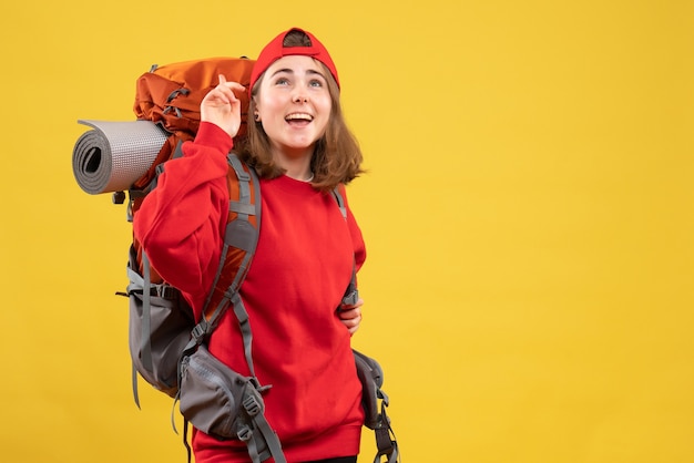 Front view cheerful female traveler with backpack looking up