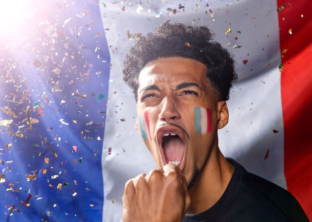 Front view of cheering man with french flag and confetti