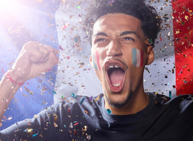 Front view of cheering man with french flag and confetti