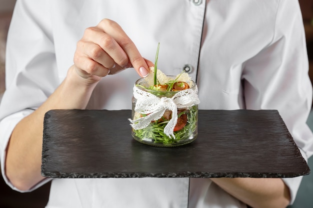 Free photo front view of  chef holding delicious food