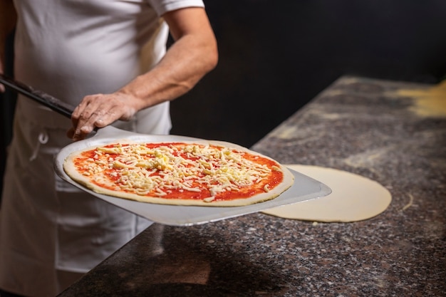 Free photo front view chef preparing pizza