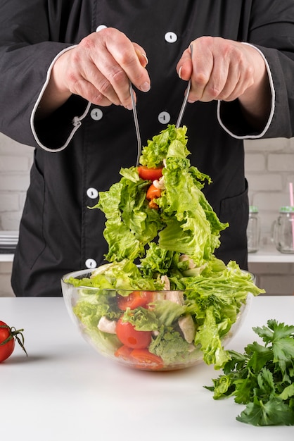 Free Photo front view of chef tossing salad