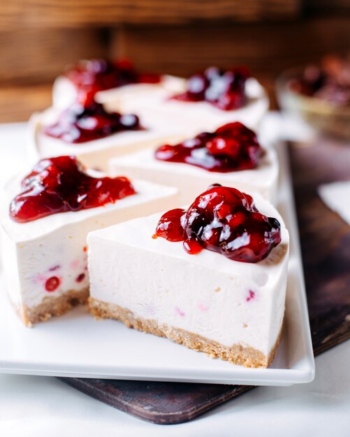 Front view cherry cheesecake yummy inside white plate on the brown surface