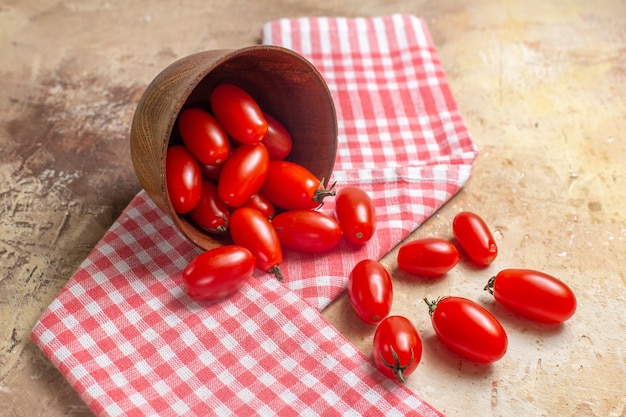 Front view cherry tomatoes scattered from bowl a kitchen towel on amber