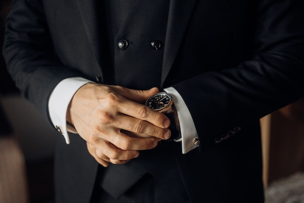 Free Photo front view of chest part of a man dressed in stylish black suit and precious watch, man's hands