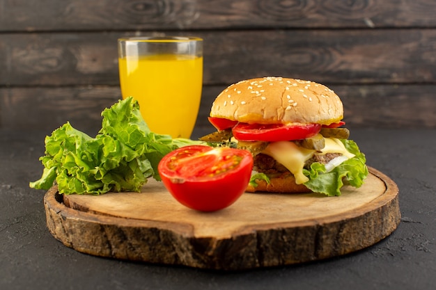 A front view chicken burger with cheese and green salad along with juice on the wooden desk and sandwich fast-food meal food