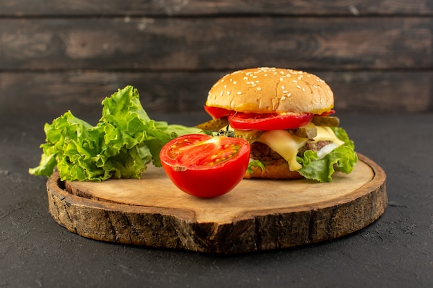 A front view chicken burger with cheese and green salad along with tomato on the wooden desk and sandwich fast-food meal food