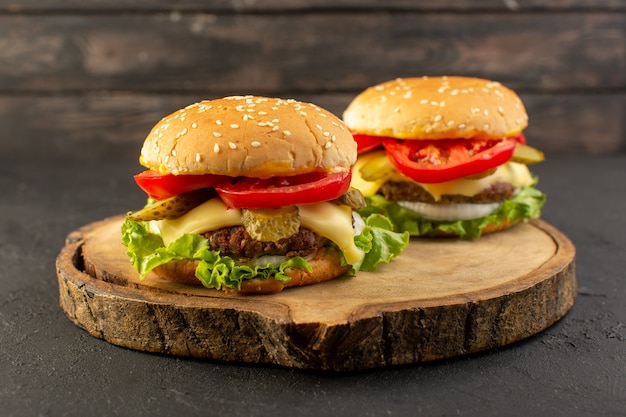 A front view chicken burgers with cheese and green salad on the wooden desk and sandwich fast-food meal food