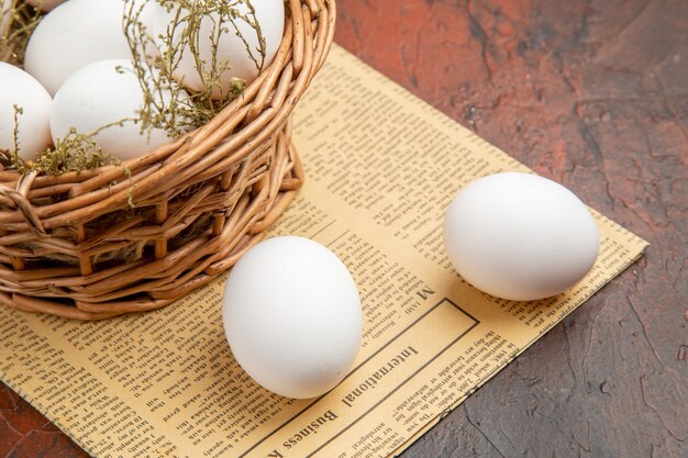 Front view chicken eggs inside basket on dark surface