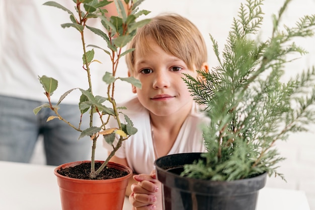 Free photo front view of child at home with dad looking at plants