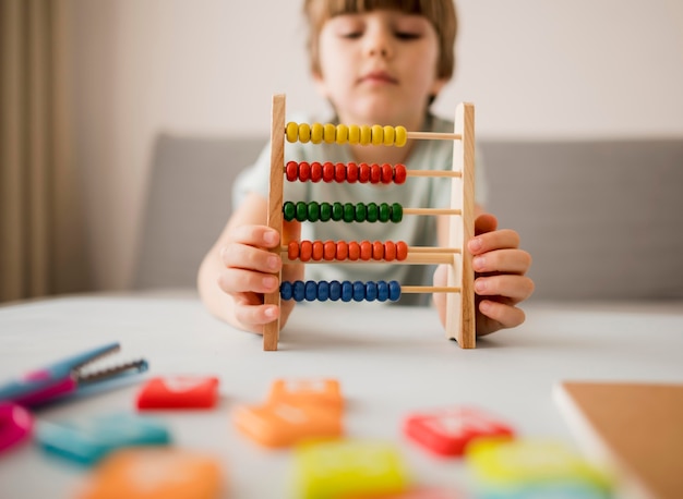 Front view of child using abacus at home