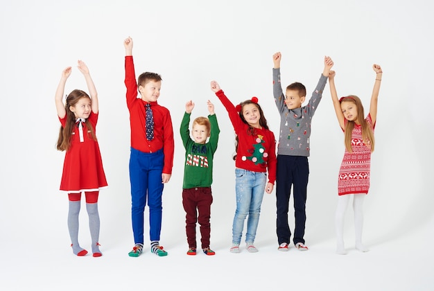 Front view of children hands up standing in a row