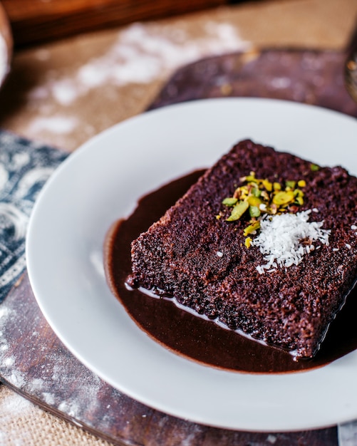 Free Photo front view choco cake tasty sweet inside white plate on the brown desk