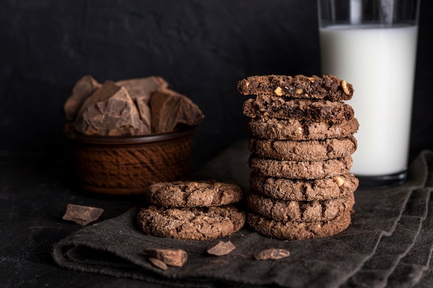 Free photo front view of chocolate cookies with glass of milk