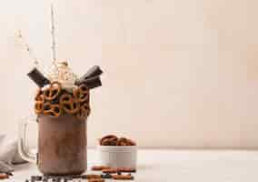 Free photo front view of chocolate milkshake glass with pretzels and copy space