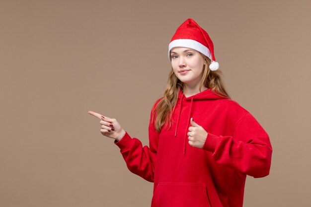 Front view christmas girl with calm face on brown background woman holiday christmas emotion