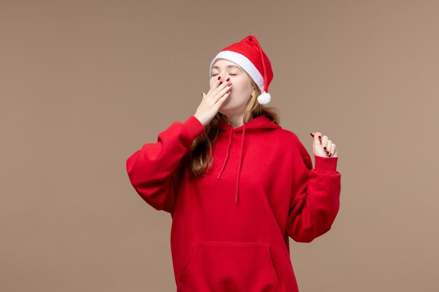 Front view christmas girl yawning on a brown background woman holiday christmas