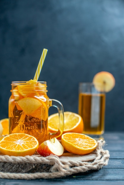 Free photo front view cocktail cut oranges and apples on wood board on dark isolated background