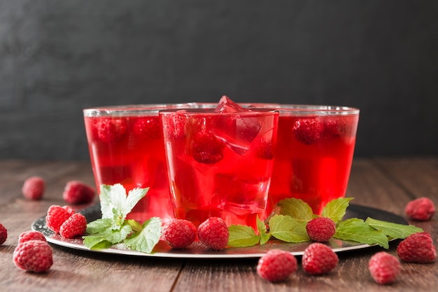 Free Photo front view of cocktail glasses with mint and raspberries