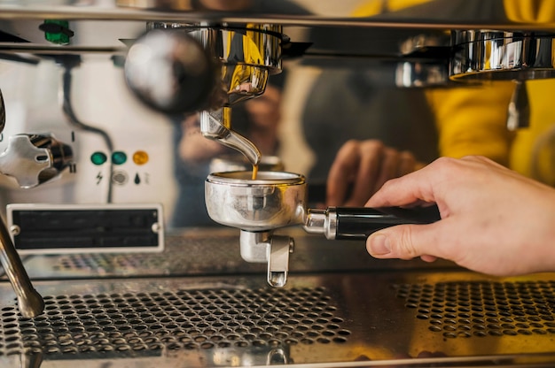 Free photo front view of coffee machine cup held by barista