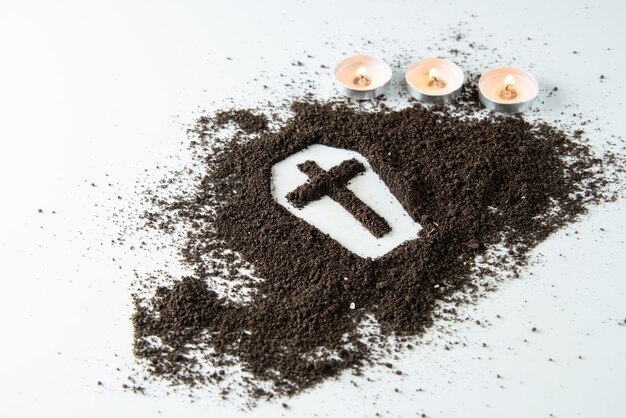 Front view of coffin shape with brown soil and candles white surface