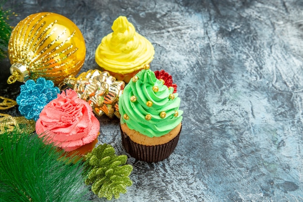 Front view colorful cupcakes xmas ornaments on grey background free place