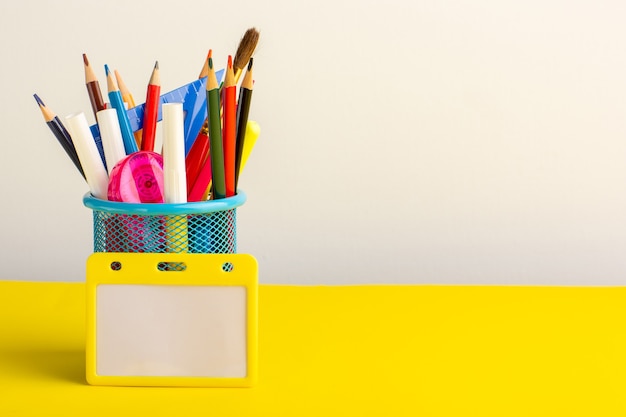 Front view colorful different pencils with felt pens on light yellow desk