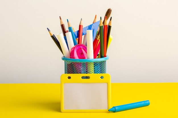 Front view colorful different pencils with felt pens on yellow desk