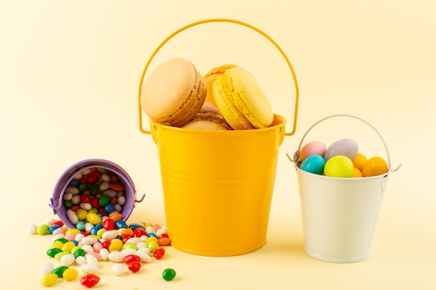 A front view colorful french macarons inside basket with candies bake