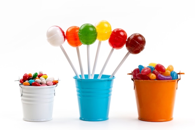 A front view colorful lollipops along with multicolored candies inside buckets on white, sweet sugar color