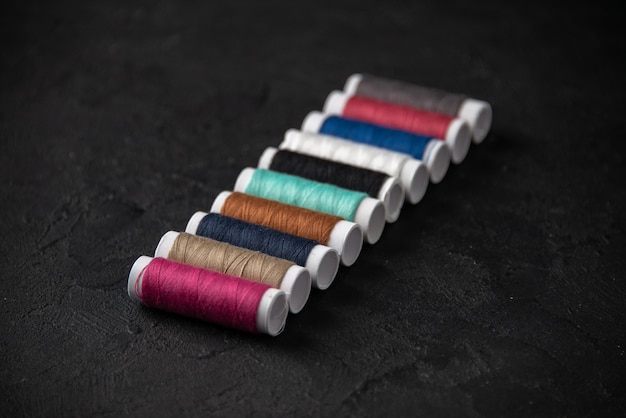 Free photo front view of colorful threads on the dark surface