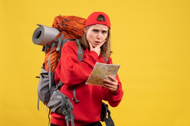 Front view confused female traveler with backpack holding map