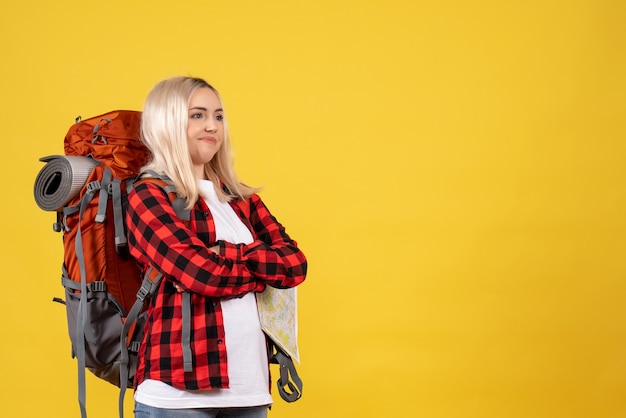 Free photo front view confused traveler woman with her backpack crossing hands standing on yellow wall