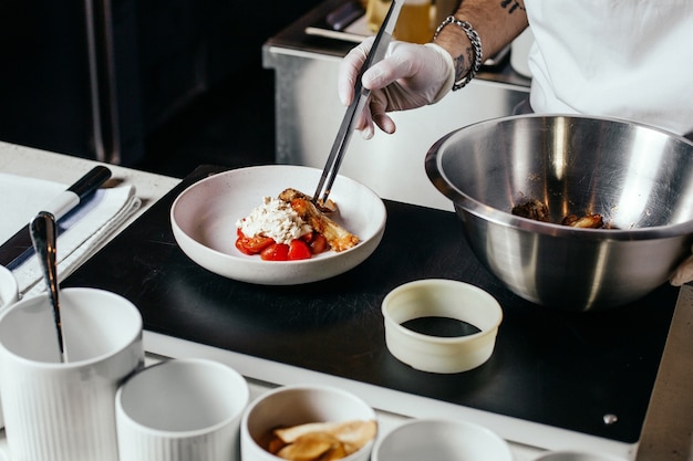 A front view cook preparing meal in white suit and gloves designing meat meal inside kitchen food meal meat