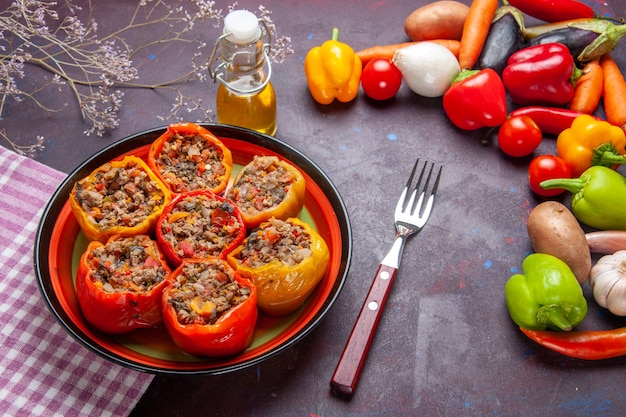 Front view cooked bell-peppers with ground meat and fresh vegetables on dark surface meal vegetable food meat dolma