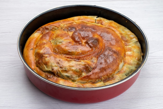 Free Photo front view of cooked greens cake inside round pan on the white surface