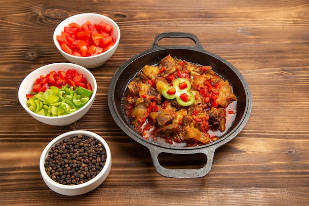 Front view cooked vegetable meal with sliced bell-pepper salad on brown desk