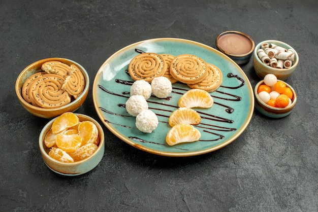 Front view cookies and candies with tangerines on grey table sweet biscuit cookie