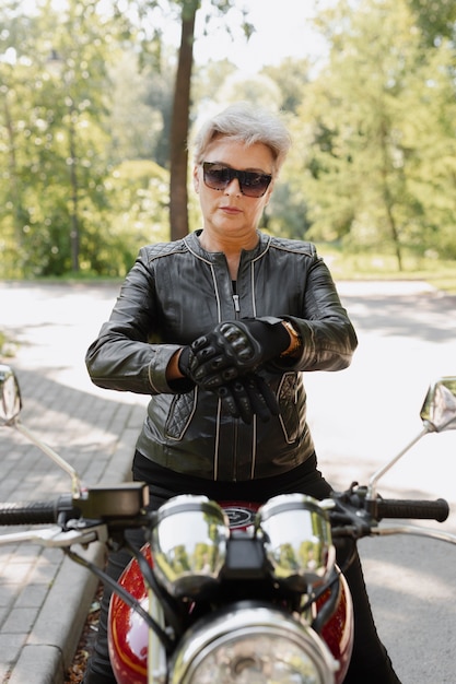 Free photo front view cool old woman with motorcycle