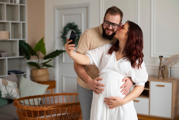 Front view couple announcing pregnancy with smartphone