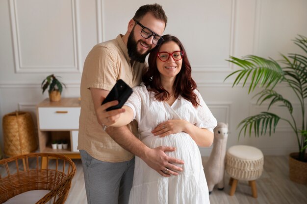 Front view couple announcing pregnancy with smartphone