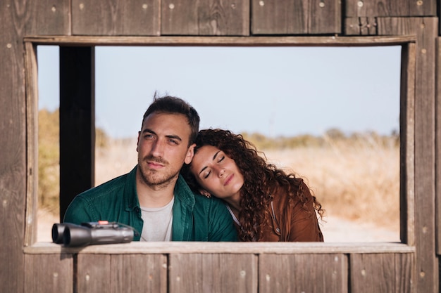 Front view couple in a bird watching shelter