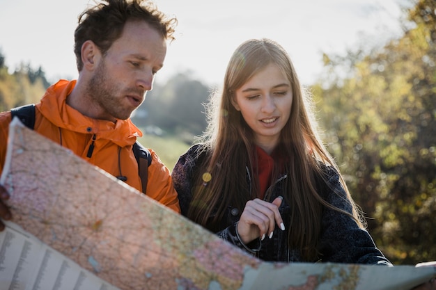 Free photo front view of couple consulting map while on a road trip