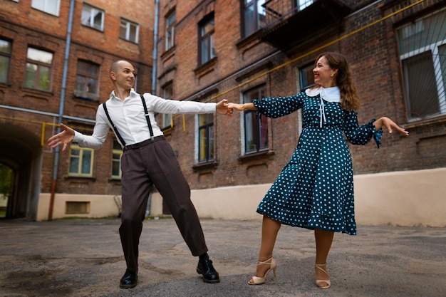 Front view couple dancing outdoors