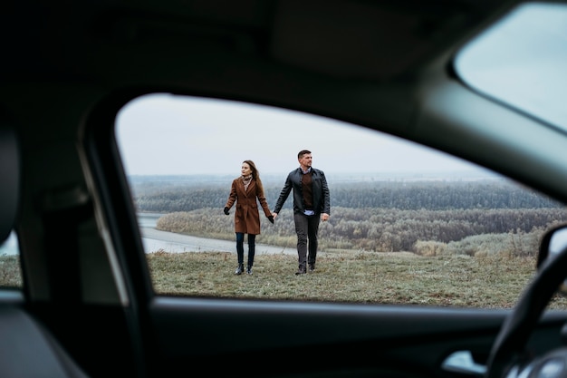 Free photo front view of couple holding hands from the inside of car