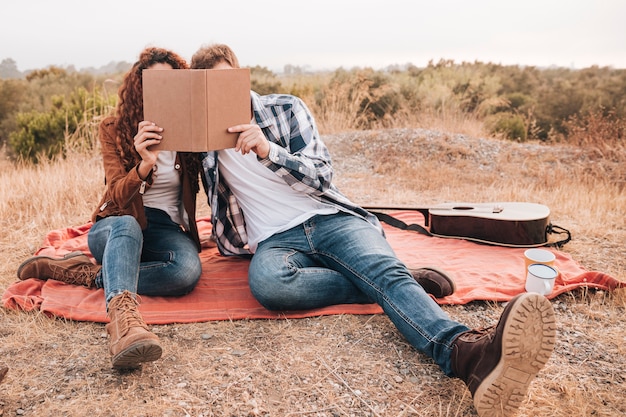 Front view couple looking on a book