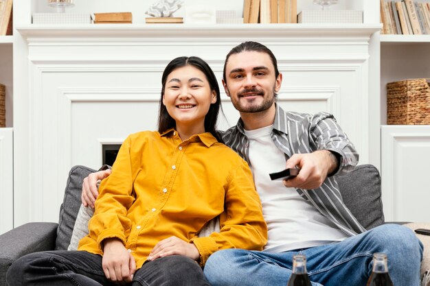 Front view couple sitting on the couch watching tv